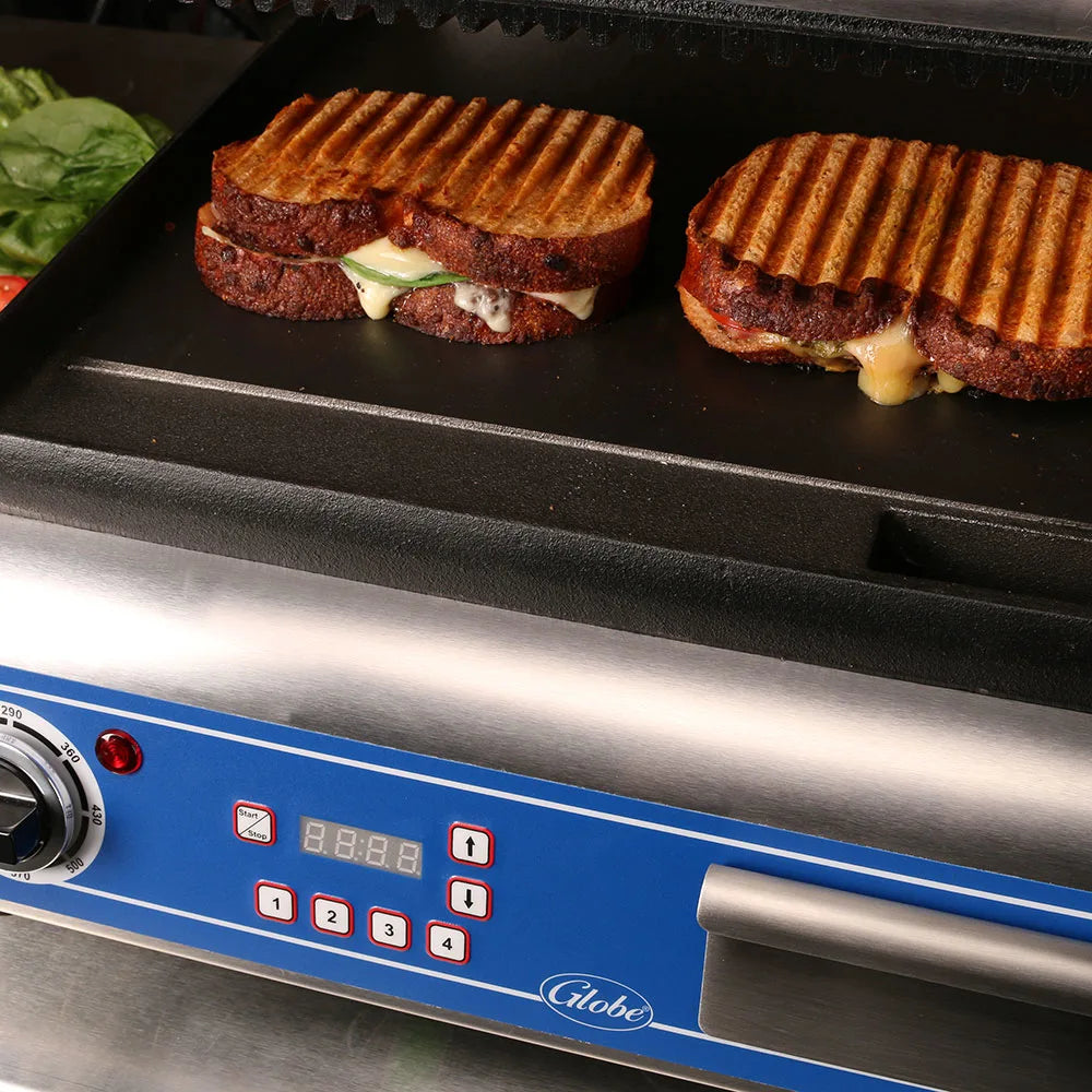 Grilled sandwiches on a panini press with visible brand 'Globe'.