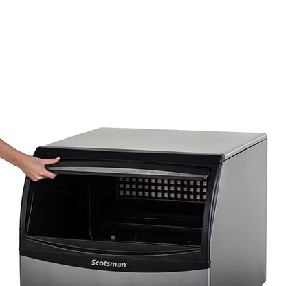  Scotsman ice machine with a hand reaching towards it on a white background