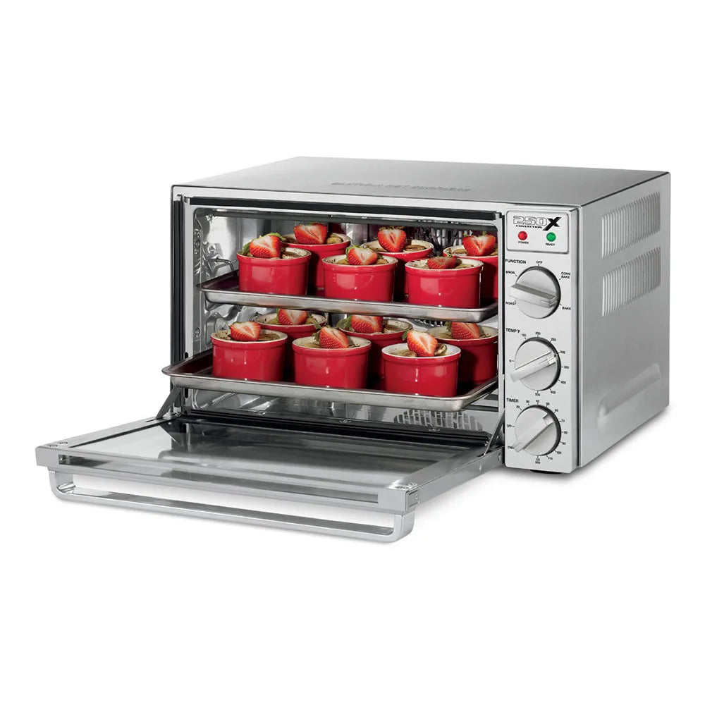 Toaster oven with red ramekins inside on a white background