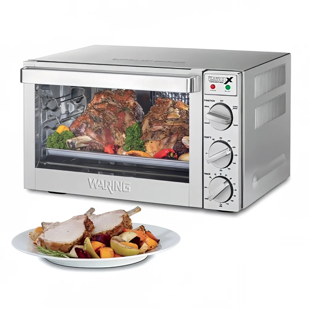 Waring toaster oven with roasted meat and vegetables inside, and a plate of food in front on a white background